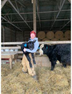 Preston Poots Jacobson holding a newborn calf